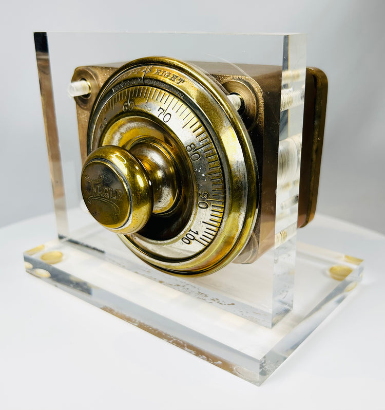 Historic safe lock front view with numbered brass dial and maker marking