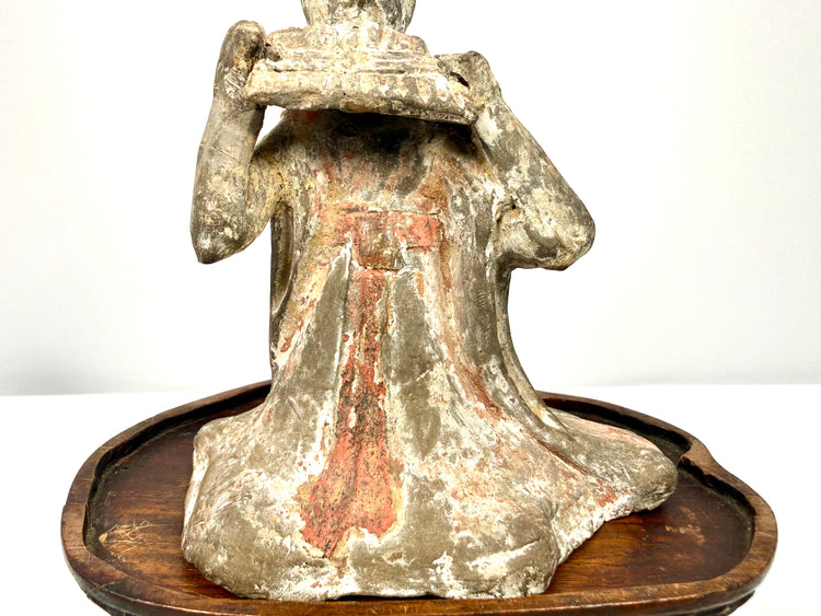 Chinese Tang Dynasty terracotta funerary figure featuring a finely modeled pan flute and intricate draped robe details.