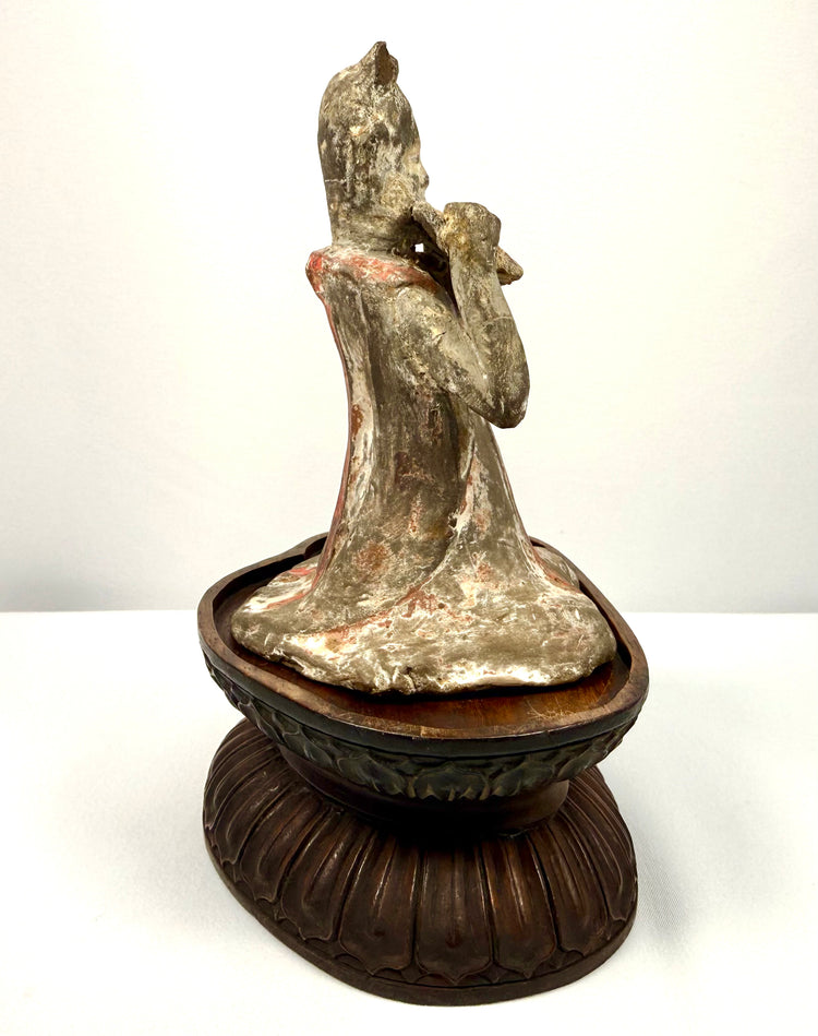 Ancient Chinese female court musician holding a pan flute, mounted on a later-added carved wooden display stand.