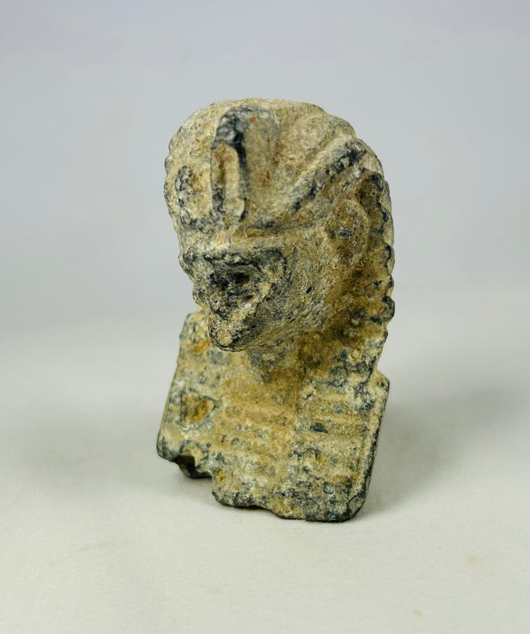 Antique limestone head of a pharaoh featuring detailed nemes headdress and cobra motif, created for the European Grand Tour era, photographed against a neutral background.