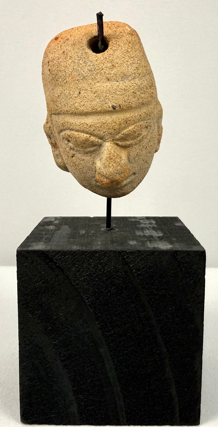 Full vertical shot of antique terracotta pendant head on display stand against neutral backdrop