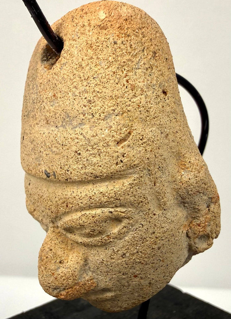 West Mexican or Veracruz terracotta head amulet with a smooth, slightly concave back and preserved suspension perforation.