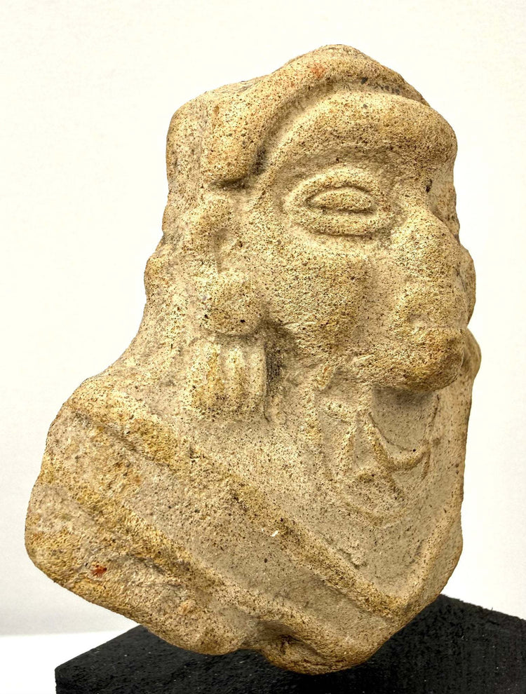 Three-quarter angle of terracotta figure fragment emphasizing eye socket depth and protruding nose