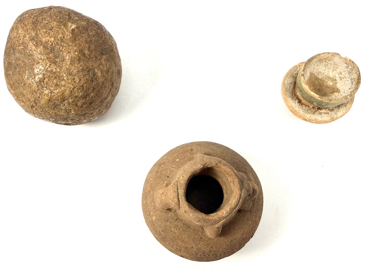 Trio of ancient artifacts: stone sphere, glazed stopper, and clay vessel