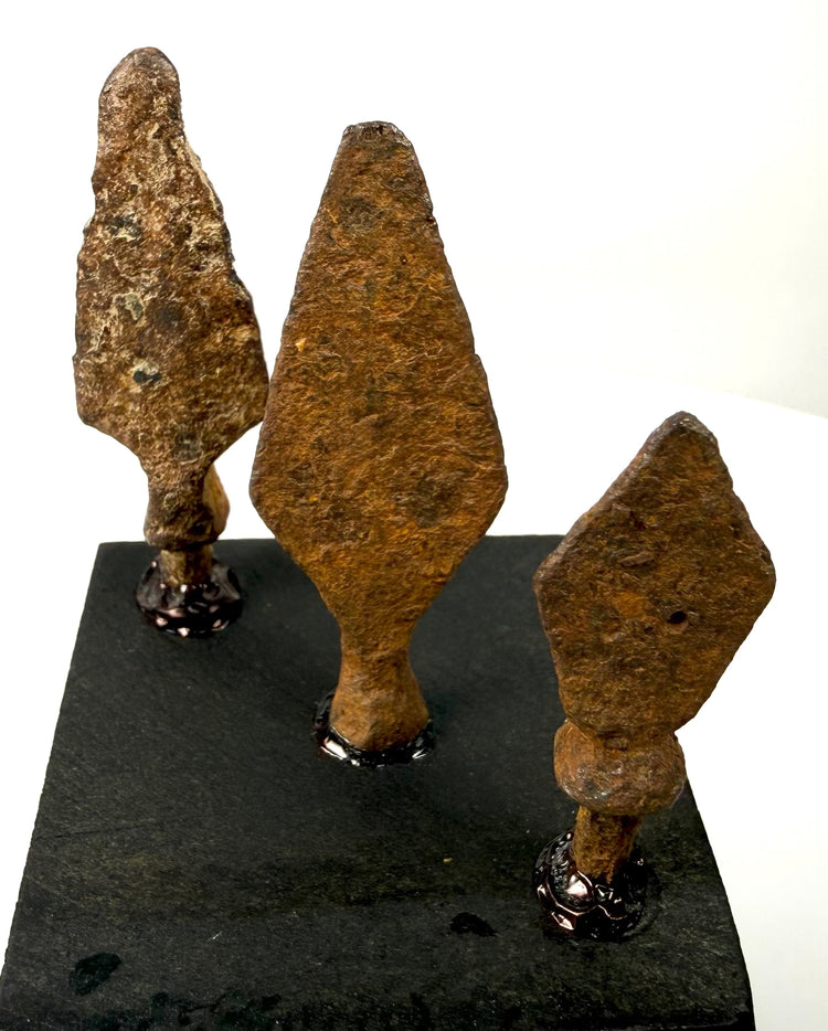 Broad leaf-shaped iron projectile point featuring a tapered blade, surviving tang, and heavily weathered surface.