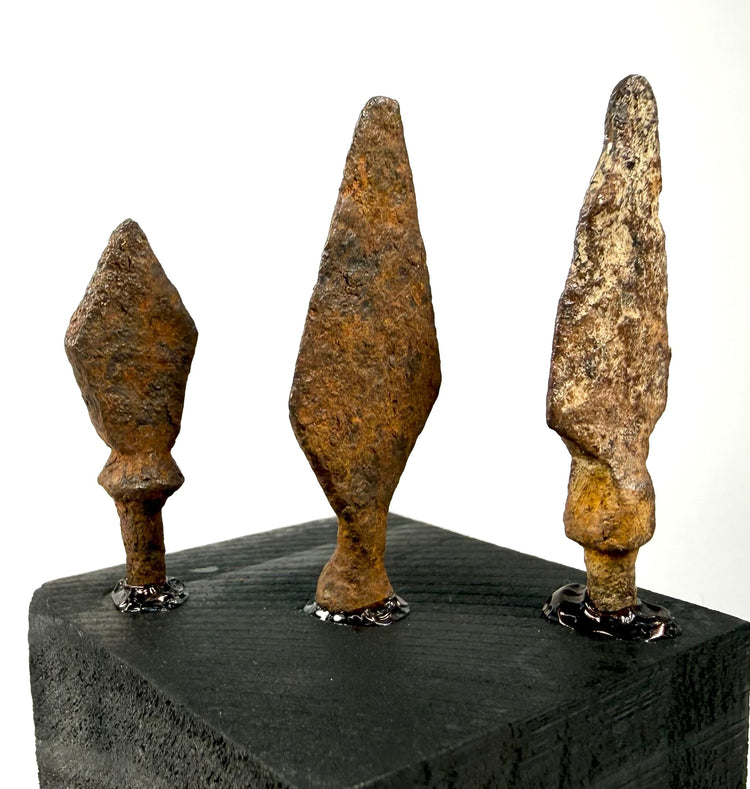 Close-up of textured Roman to medieval iron projectile points with diamond blade forms