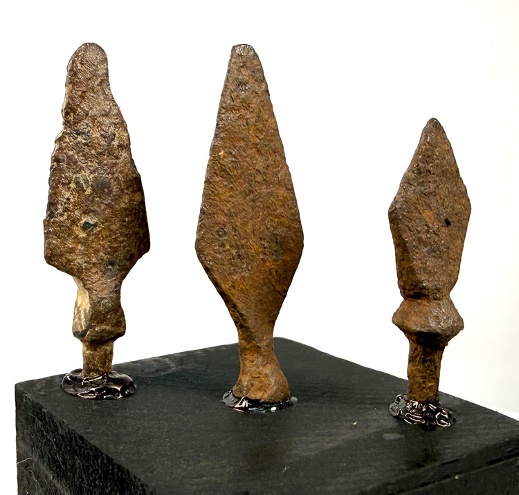 Medieval era iron arrowheads mounted on black base with visible attachment details