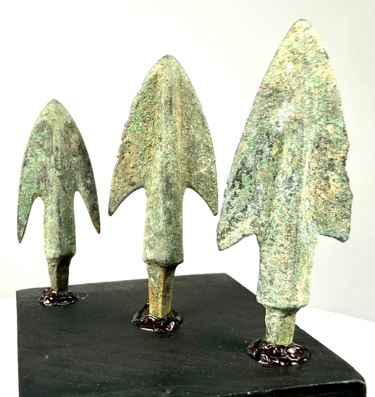 Frontal arrangement of barbed bronze spearheads with corrosion layers