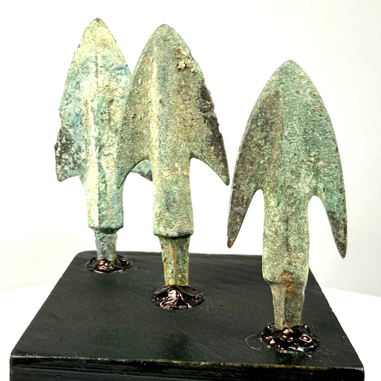 Angled view of antique bronze weapon heads highlighting blade variation