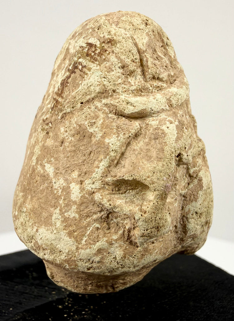 Rear view of beige Mesopotamian limestone idol head with rough unfinished back