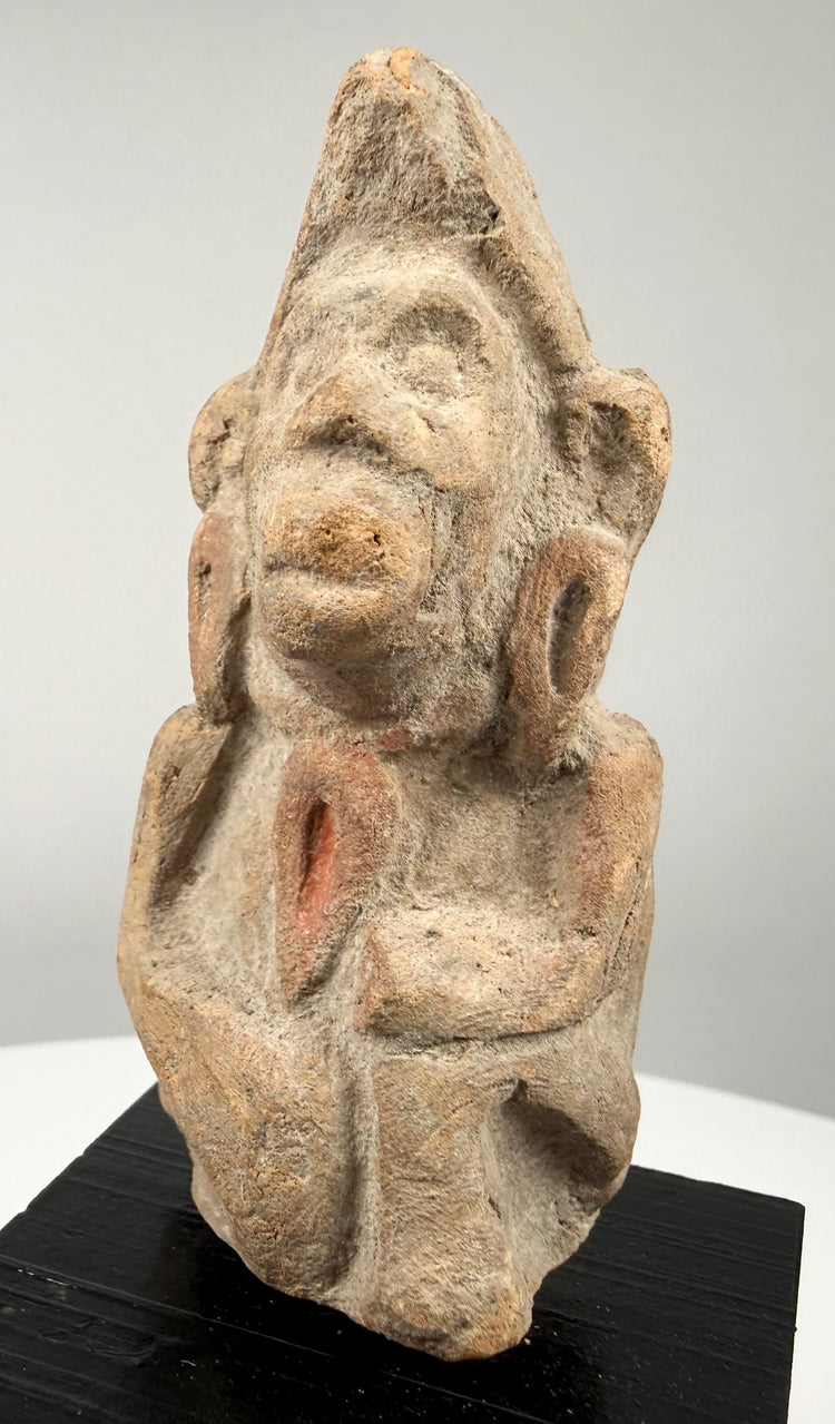 Antique South Asian terracotta votive figurine featuring a stylized anthropomorphic form and traces of ancient surface pigment.