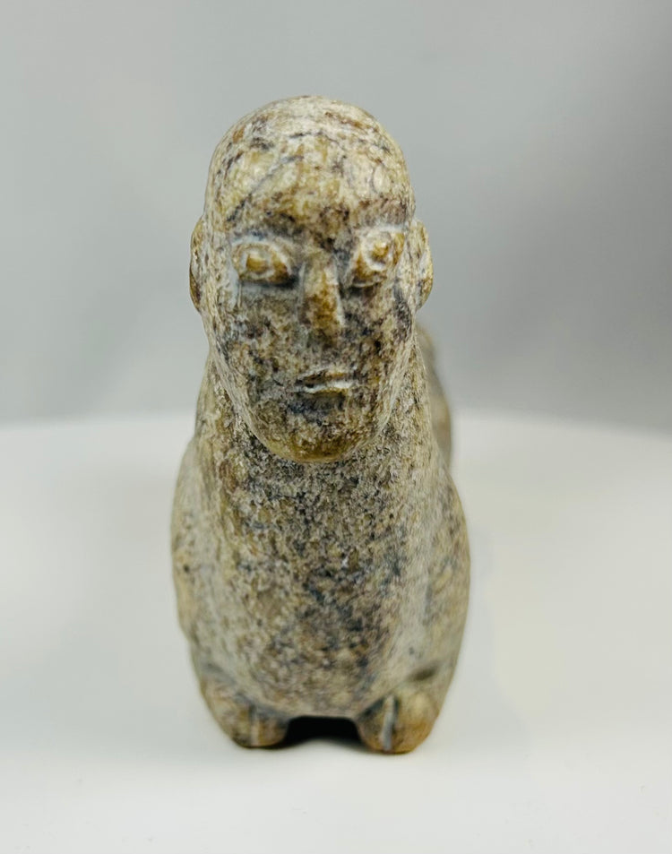 Hand carved stone effigy from West Africa with elongated body and upright neck