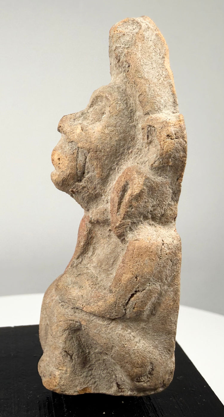 Early Indian devotional artifact featuring hand-molded terracotta construction, detailed facial features, and a modern black display base.