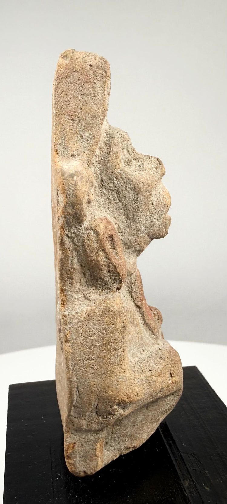 Right profile silhouette of handmade clay figurine emphasizing material grain