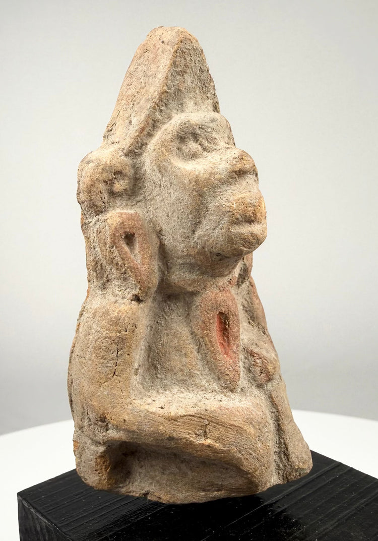 Three-quarter angle of terracotta statue with looped ear ornaments and red pigment