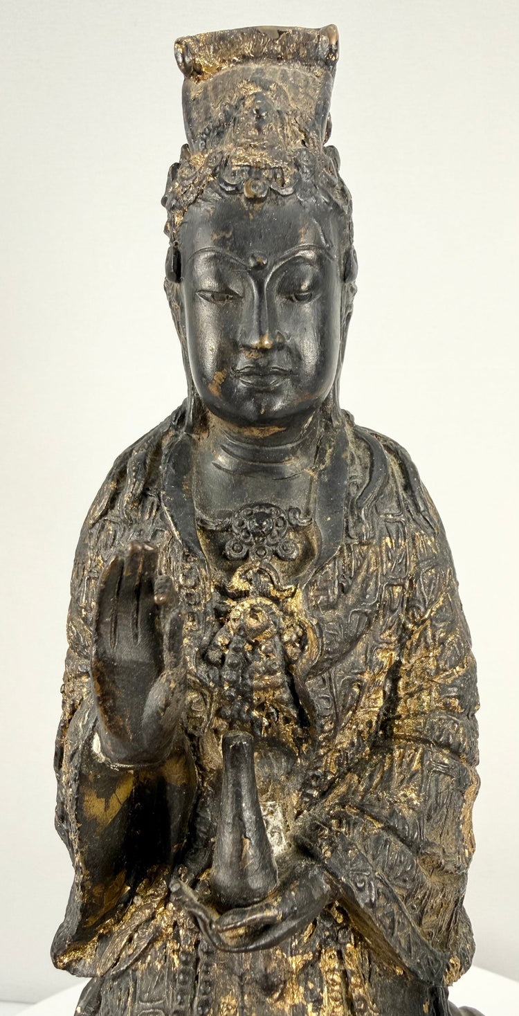 Close-up of serene antique gilt bronze Bodhisattva face and ornate crown