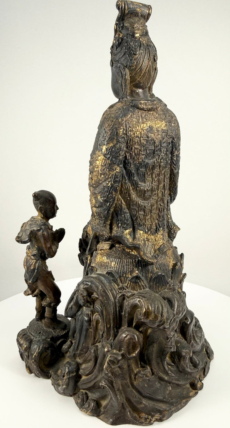 Back detail of antique bronze Guanyin statue showing robe patterns and gilt wear