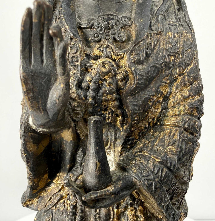 Macro detail of mudra hand gesture and chest ornamentation on bronze Bodhisattva