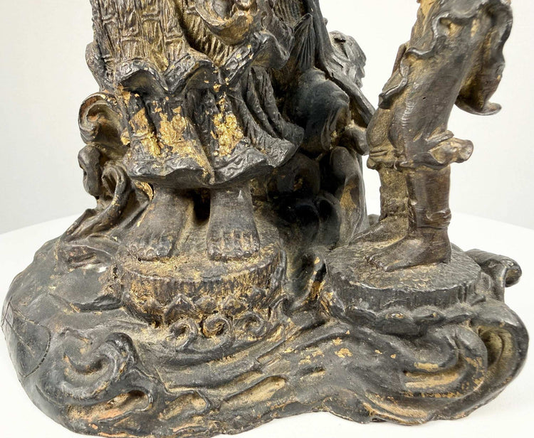 Detail of carved wave motifs and gilt wear on antique bronze sculpture base