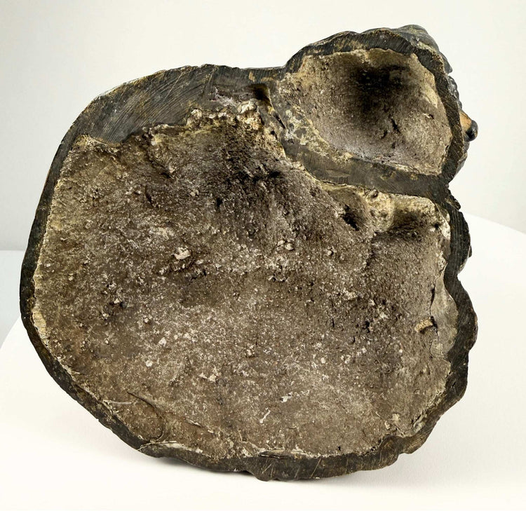 Underside of cast bronze sculpture base showing casting seams and oxidation