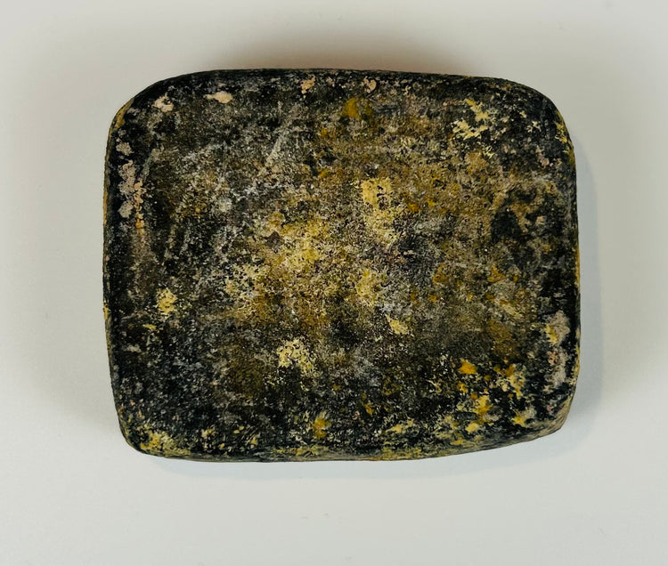 Ancient stone plaque with incised lines and weathered surface