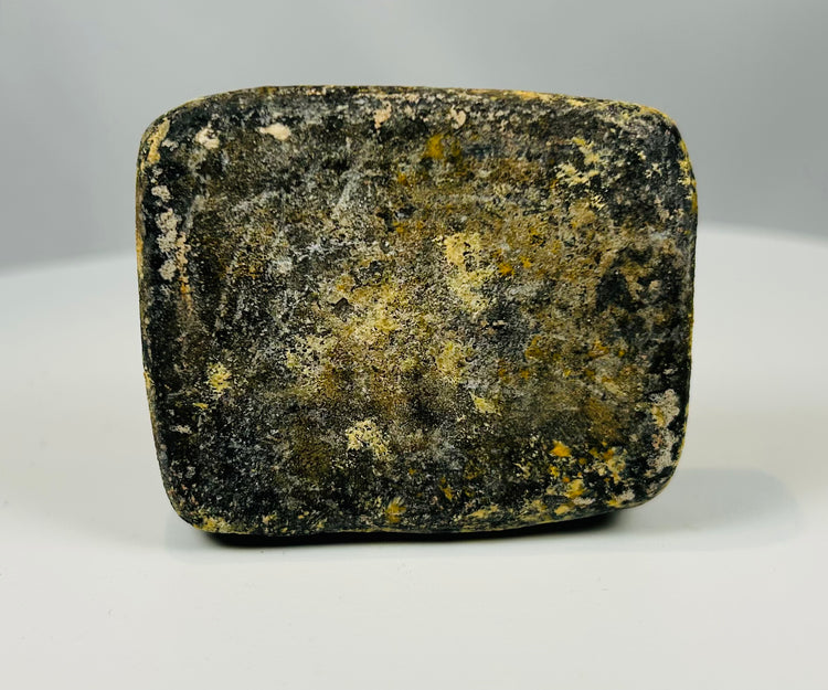 Small ancient stone plaque with rounded edges and incised decoration