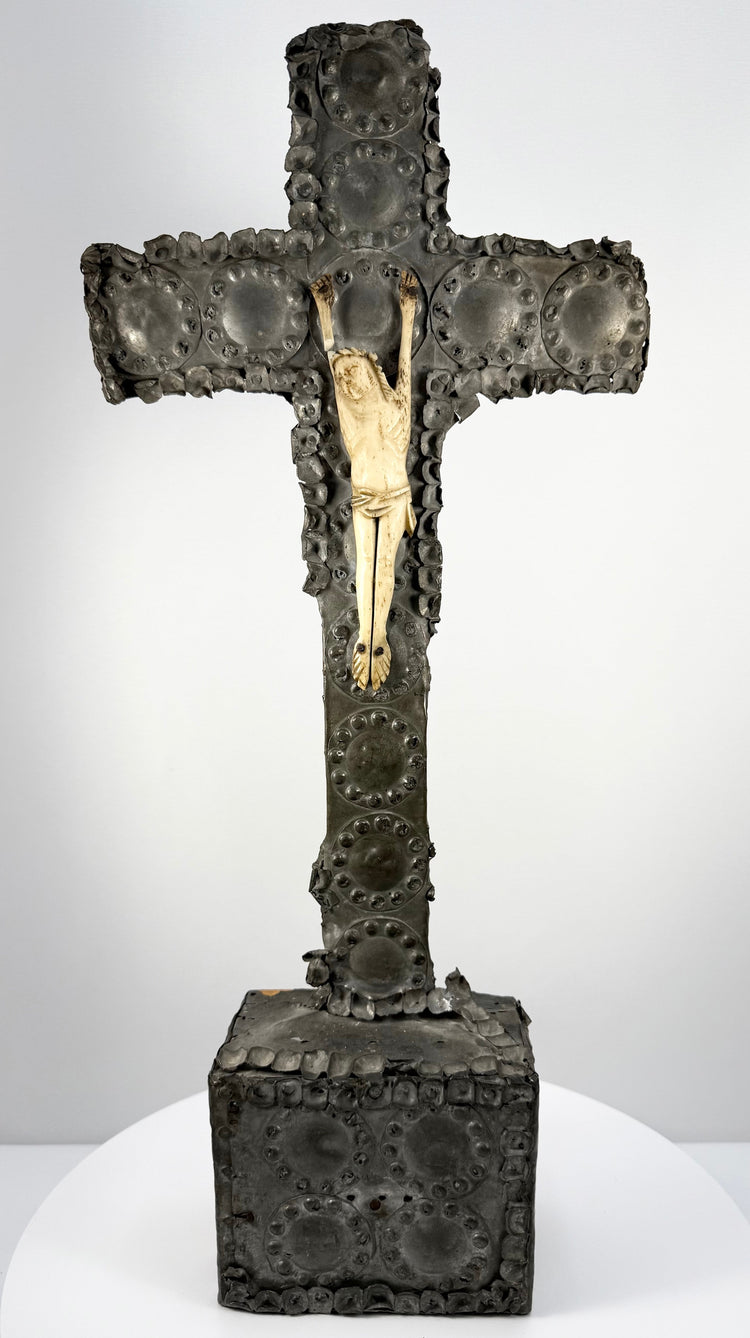 Frontal view of cream bone corpus attached to dark tin-sheathed cross