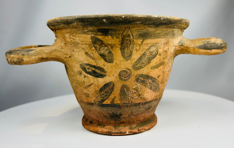Terracotta skyphos with painted rosette and visible wheel marks