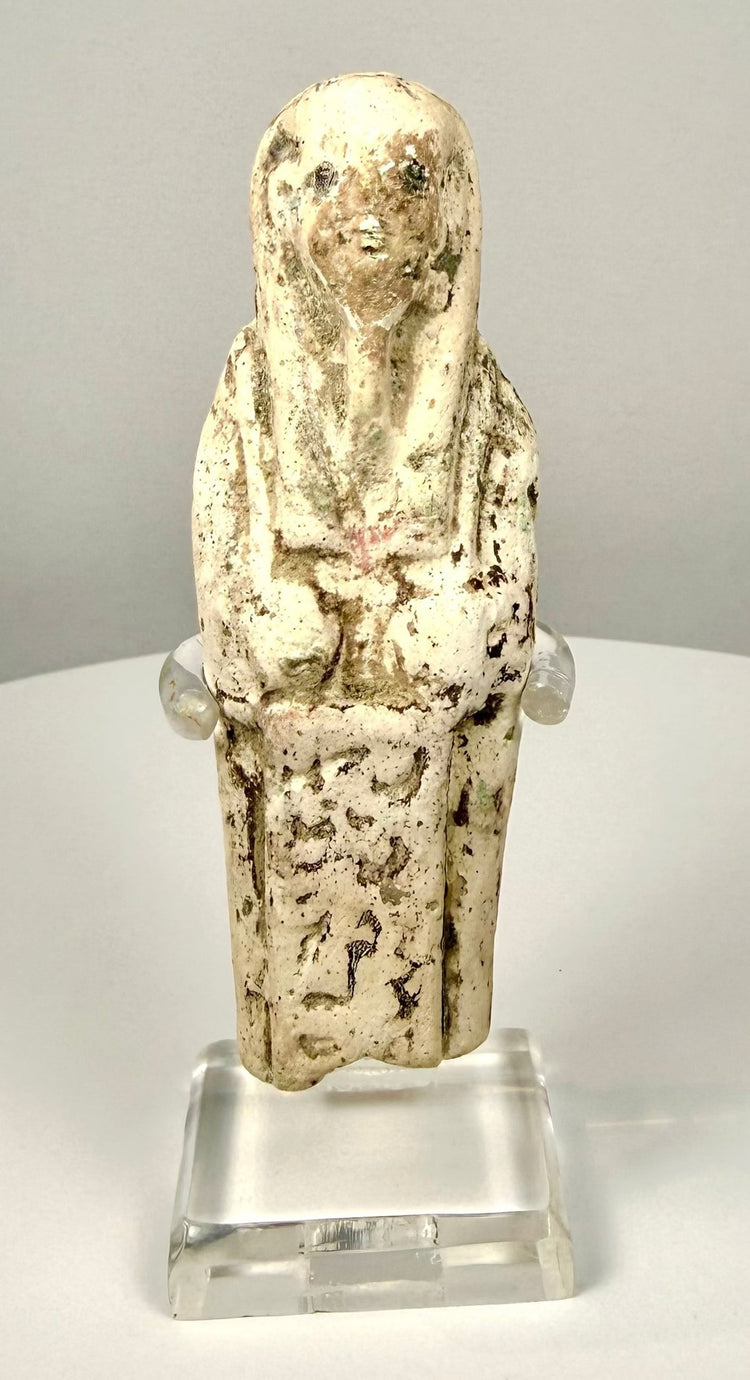 Egyptian limestone shabti depicting a standing mummiform figure with folded arms and a traditional tripartite wig.