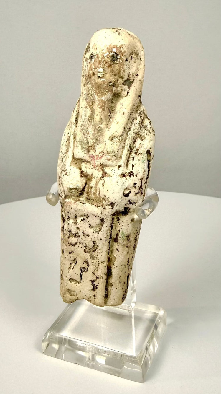 Ancient Egyptian shabti displaying folded arms and prominently modelled hands beneath a traditional funerary wig.