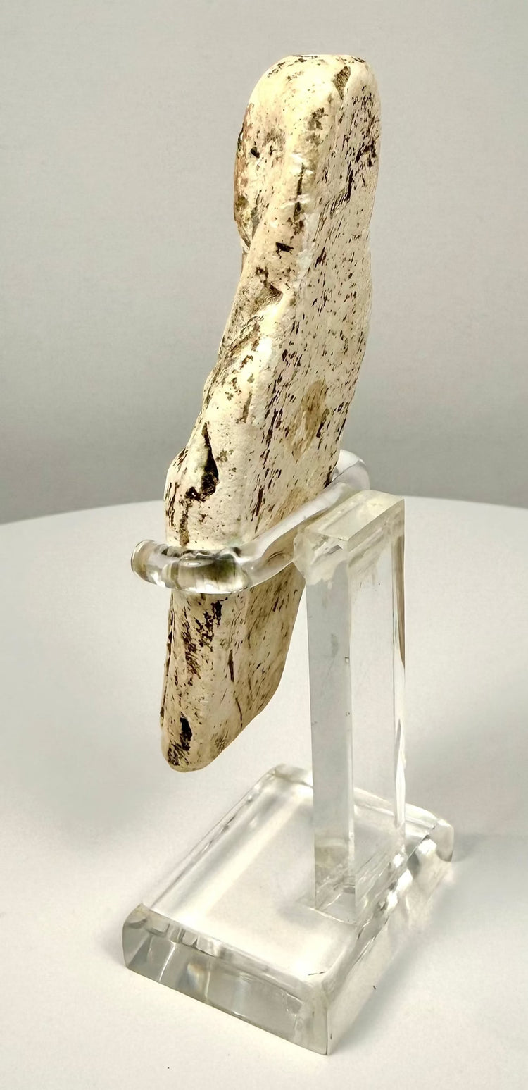 Limestone shabti figure showing surface abrasion, irregular brown patination, and softened carved details consistent with its aged appearance.