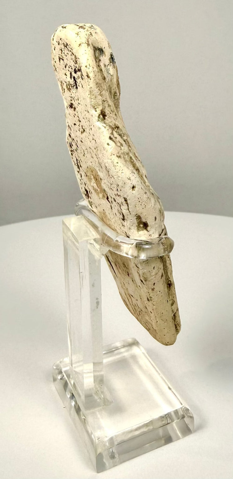 Egyptian shabti figurine featuring an aged limestone surface with small pits, localized losses, and darker mineral staining.