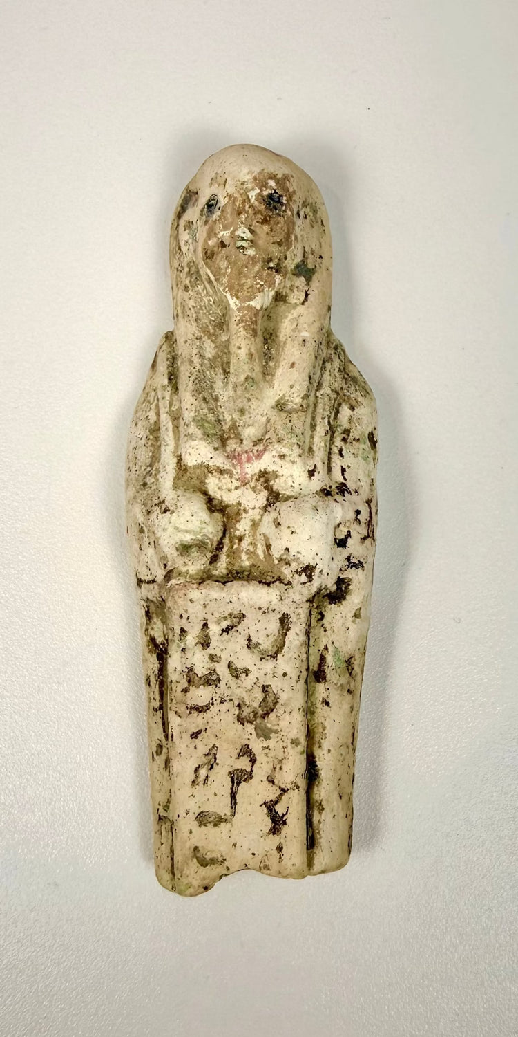 Egyptian limestone shabti mounted on a modern clear acrylic display stand, highlighting its traditional mummiform silhouette.