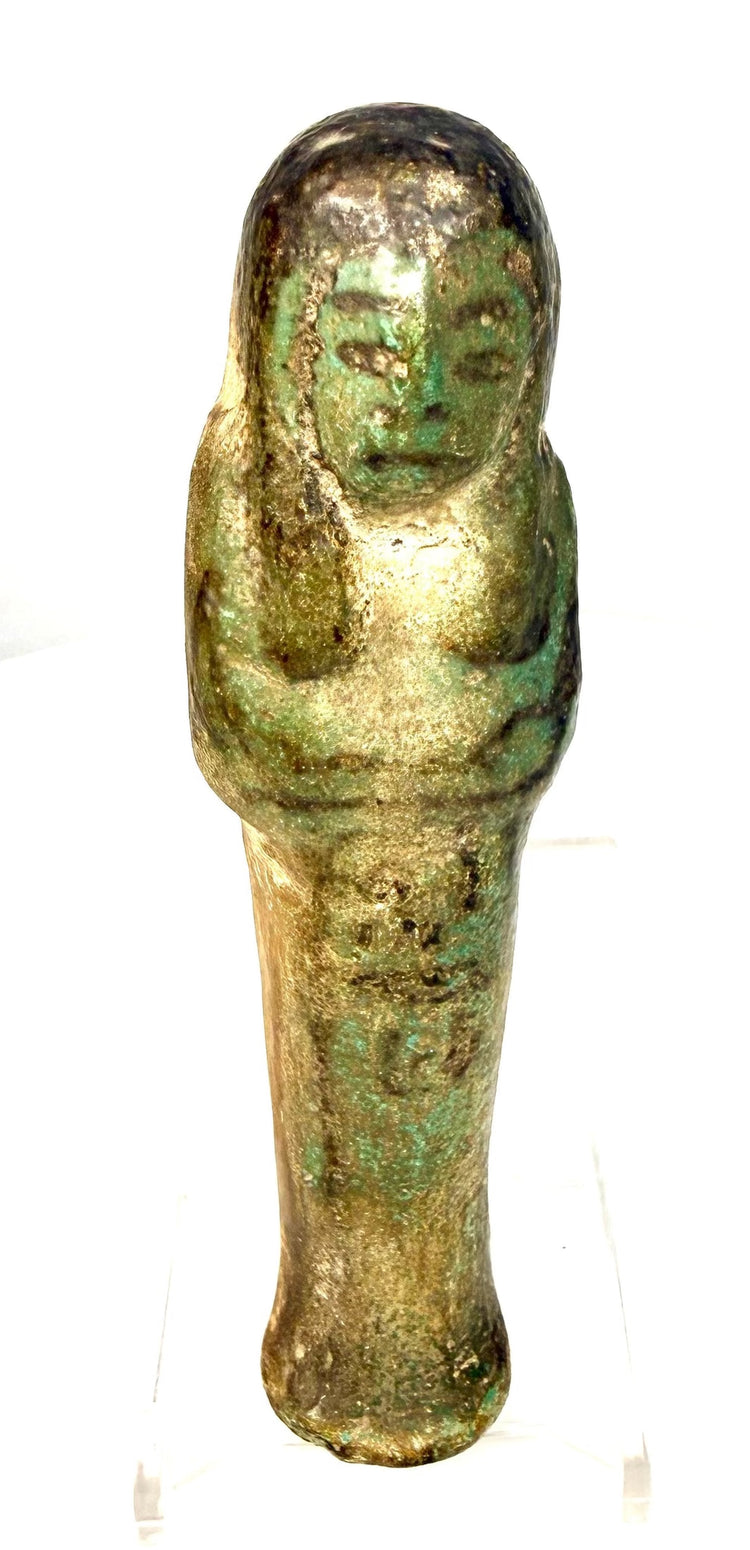 Ancient Egyptian ushabti displaying areas of glaze loss, surface pitting, and mineral deposits across its faience body.