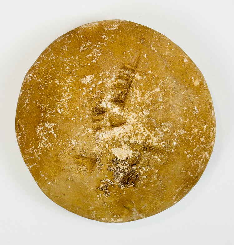 Handheld ancient seal with circular form and symbolic design