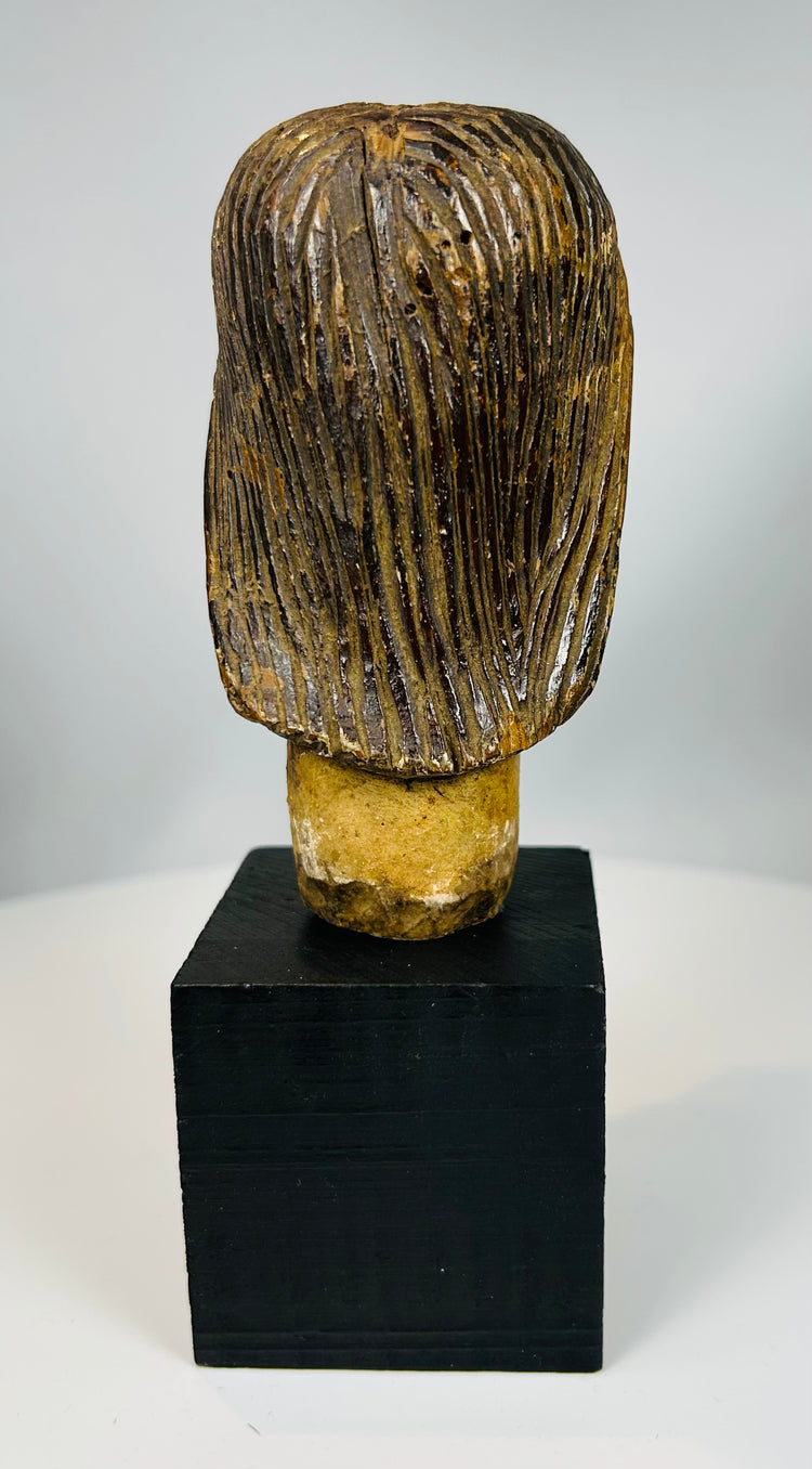 Carved Christ head mounted on display base with aged surface