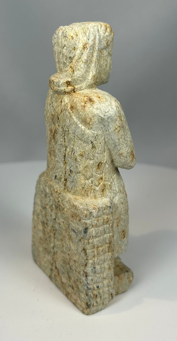 Ancient stone votive figure with hands clasped in prayer posture