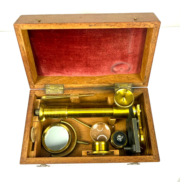 Antique mahogany microscope carrying case featuring traditional wooden construction, decorative brass fittings and period craftsmanship.