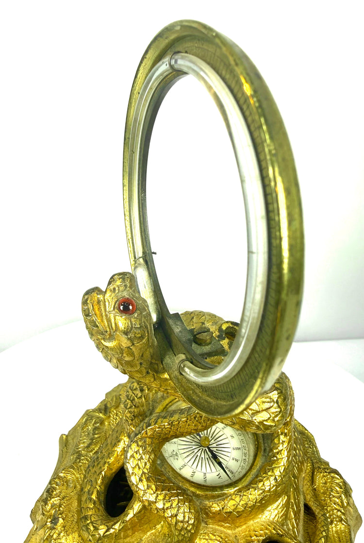 Victorian bronze serpent inkstand with an inset compass displaying a decorative compass rose and directional markings beneath glass.