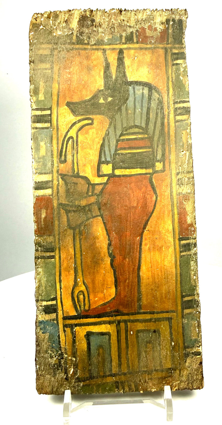 Egyptian painted wood funerary fragment featuring Duamutef with a black jackal head, striped headdress, and reddish-brown mummiform body.