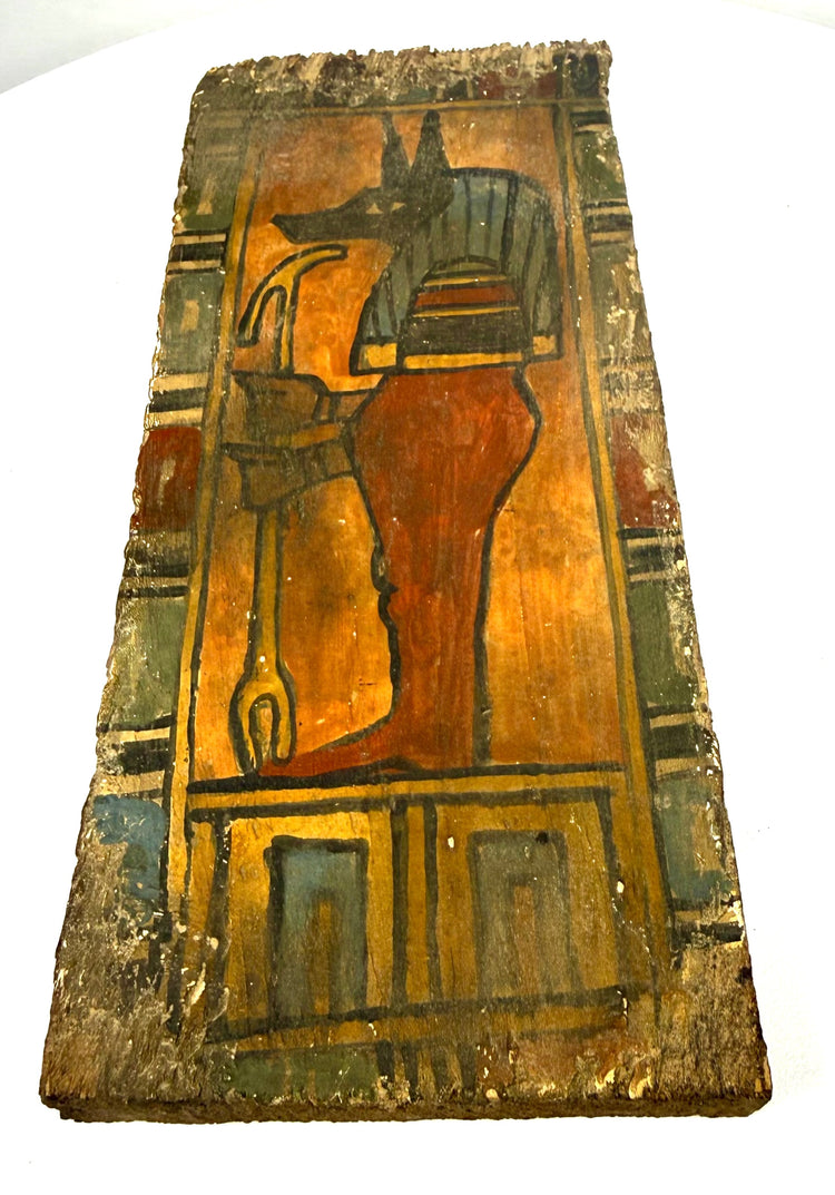 Ptolemaic painted wooden panel featuring Duamutef against an ochre-orange background with architectural and shrine-like decorative elements.