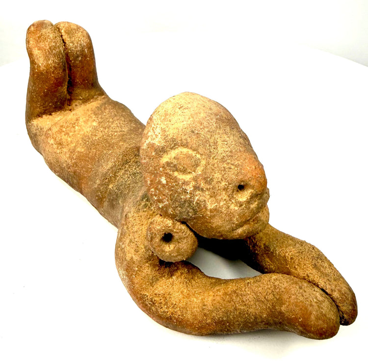 Pre-Columbian terracotta human effigy displaying a broad forehead, subtly modelled eyes, projecting nose, and gently defined mouth.