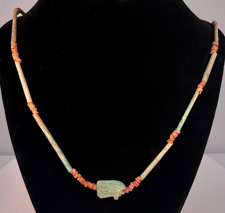 Ancient Egyptian faience necklace displaying elongated turquoise-blue cylindrical beads separated by small earthen-toned disc spacers.