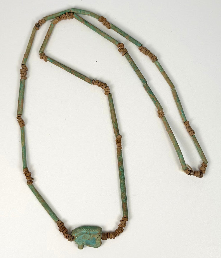 Turquoise-green Egyptian faience beads exhibiting natural surface deposits, glaze wear, and variations in blue-green coloration.