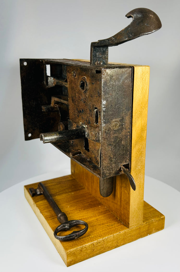 Vintage iron lock mechanism showing internal levers, springs, and key operation