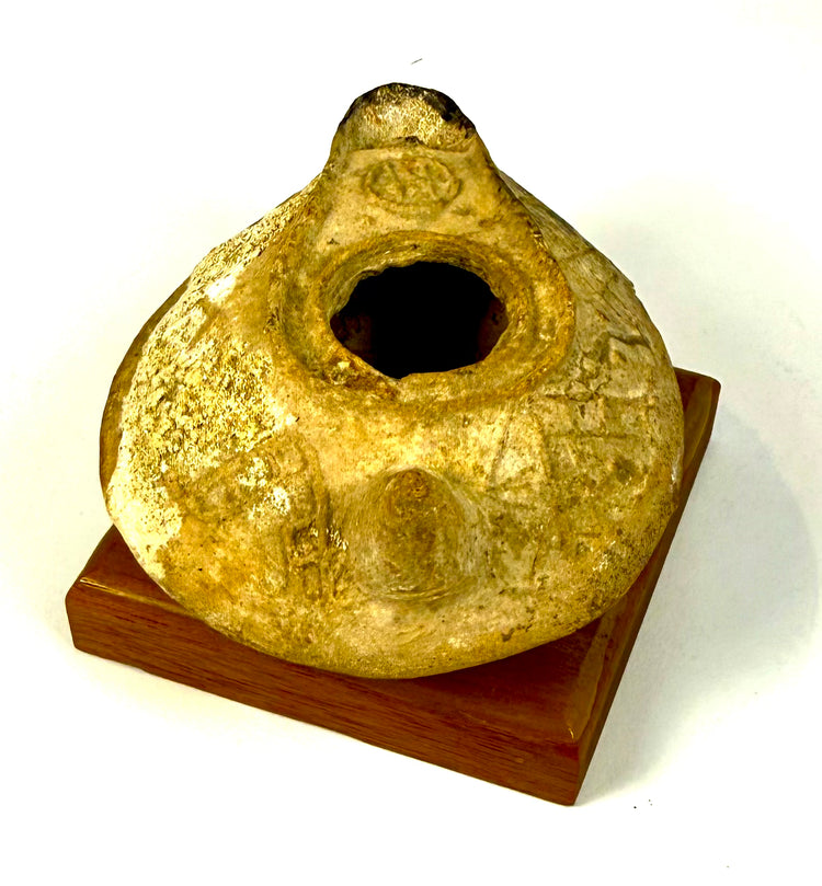 Byzantine slipper-shaped oil lamp displaying intricate geometric relief decorations, pale encrustations, and natural surface wear.