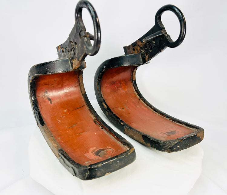 Pair of antique Japanese lacquered samurai stirrups with red interiors and black lacquered exteriors, Edo–Meiji period design, displayed on a white background.