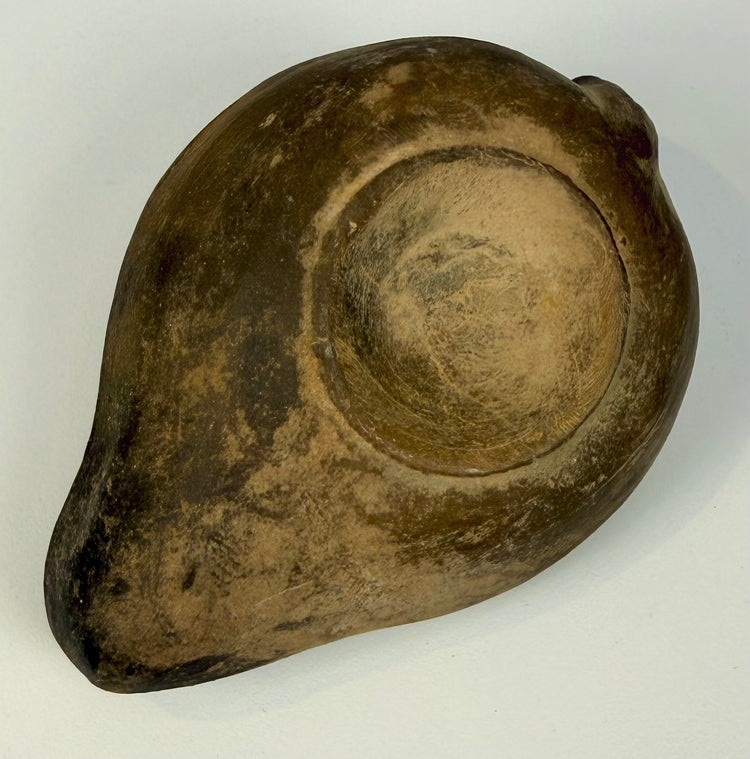 Roman mould-made ceramic oil lamp with recessed circular underside, aged terracotta coloration, and surface abrasions.