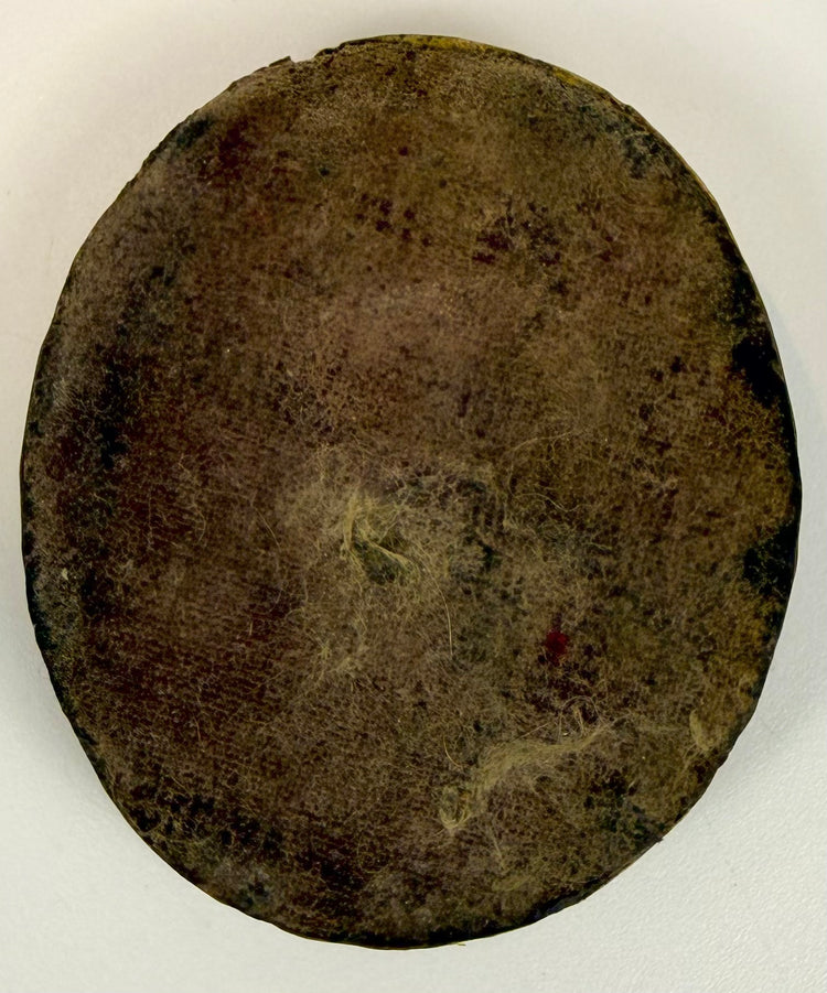 Reverse of an antique Russian Orthodox enamel Gospel-cover plaque showing aged backing material, fibrous texture, and historical surface wear.
