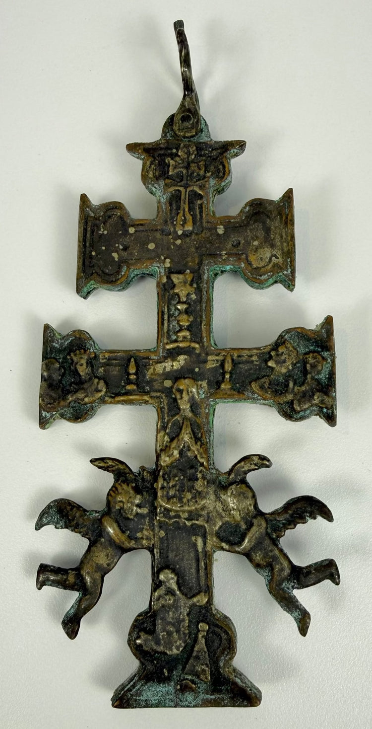Antique Spanish religious cross displaying distinctive double horizontal arms, ornamental terminals, and elaborate pierced bronze metalwork.
